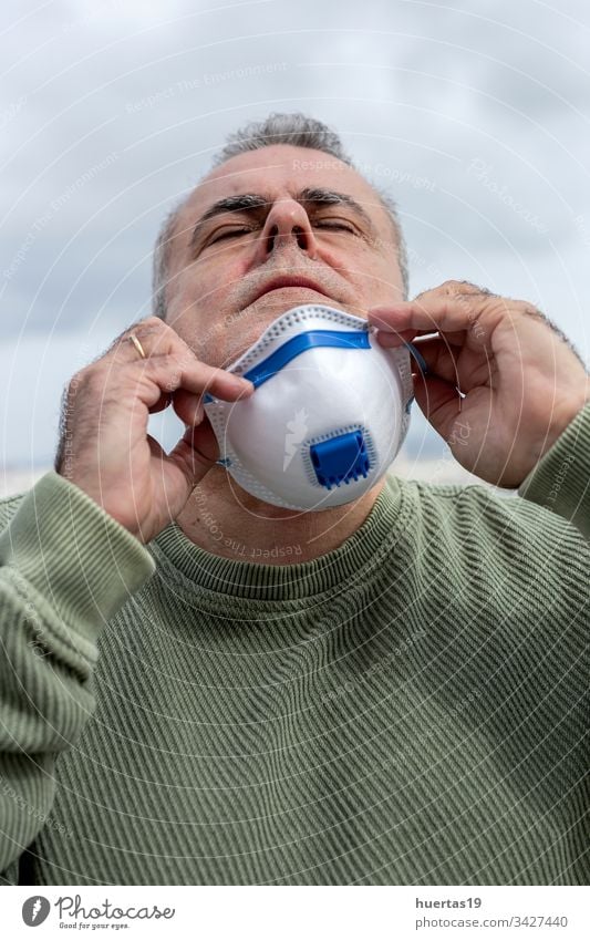 Erwachsener Mann mit Schutzmaske für Coronavirus medizinisch Mundschutz Seuche schützend Infektion Virus covid-19 Gesundheit Thermometer Grippe Gesicht Pandemie