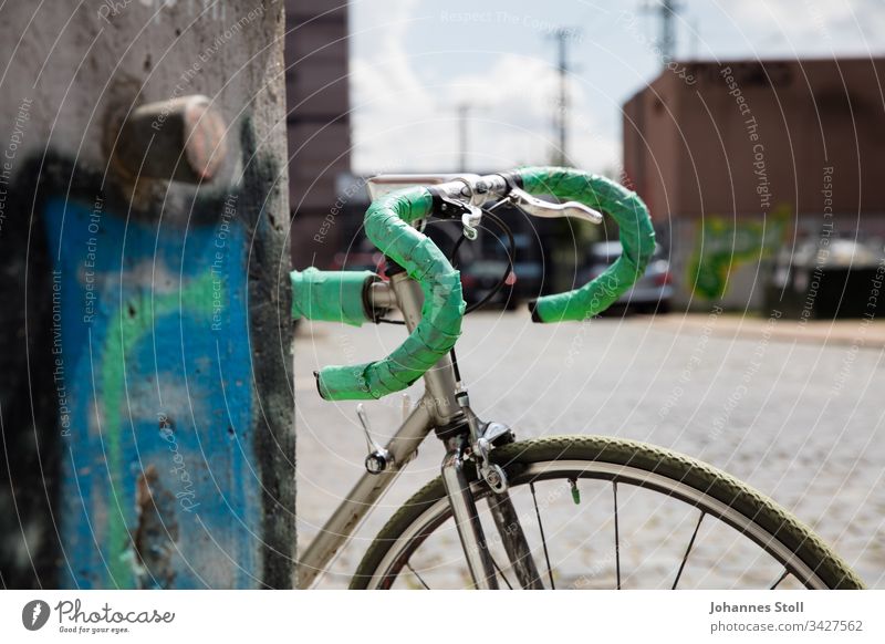 Vintage Rennrad mit grünem Lenkerband an Graffiti-Mauer gelehnt Retro Stahl Aluminium Fahrrad Hipster urban Stadt Verkehr Pendler City Sonne Rad Radfahrer