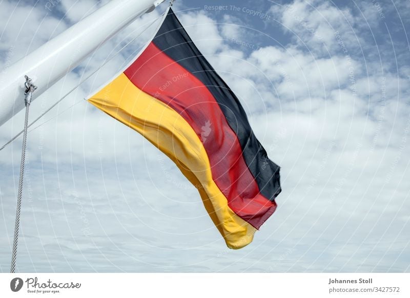 Deutschlandfahne im Wind Fahne Flagge Schwarz Rot gold Stoff Schiff Fahnenmast Seil Himmel Wolke Feiertag Feierlichkeit Stolz Nation Gesellschaft Einheit