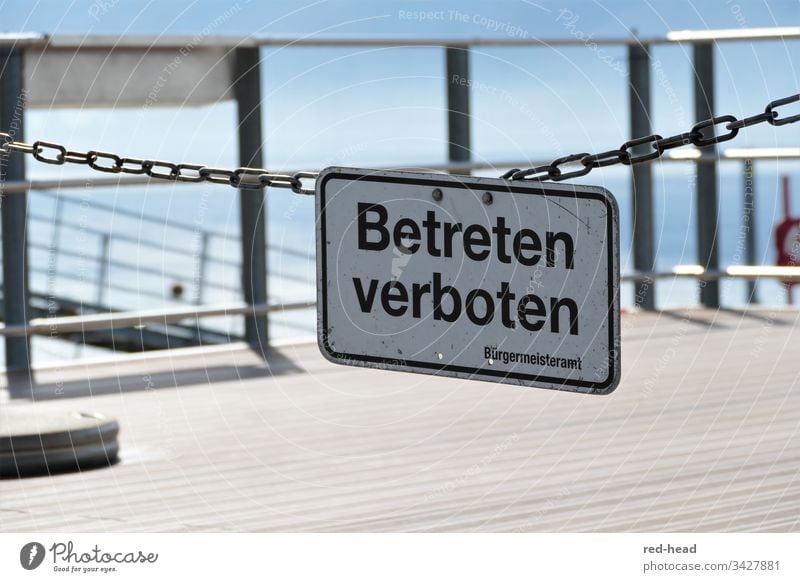 Betreten Verboten - Schild an Gliederkette vor Bootsanlegestelle, im Hintergrund Geländer, hellblauer Himmel und See Betreten verboten Schilder & Markierungen