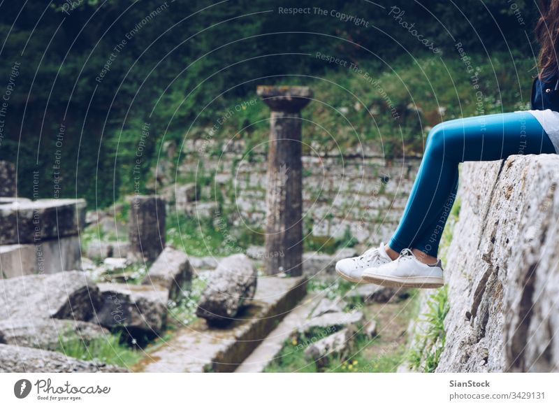 Mädchen sitzt auf Überresten eines dorischen Tempels, Mon Repos-Park, Korfu-Stadt, Griechenland Palast repo repos kerkira Insel Gebäude Wahrzeichen historisch