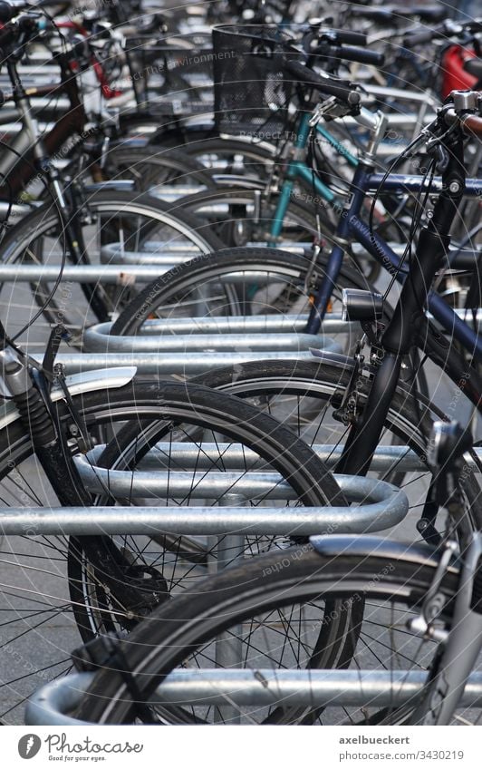 Fahrradständer mit vielen Fahrrädern stehen parken Fahrradfahren Rad Verkehr Sport Großstadt urban Parkplatz Stadt Verkehrsmittel voll umweltfreundlich autofrei