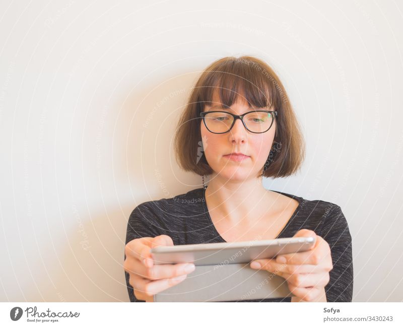 Kaukasische Frau mit Brille, die eine Tablette benutzt benutzend Apparatur Sitzen Kaukasier Porträt Mitte Arbeitswohnung Quarantäne bob horizontal gealtert
