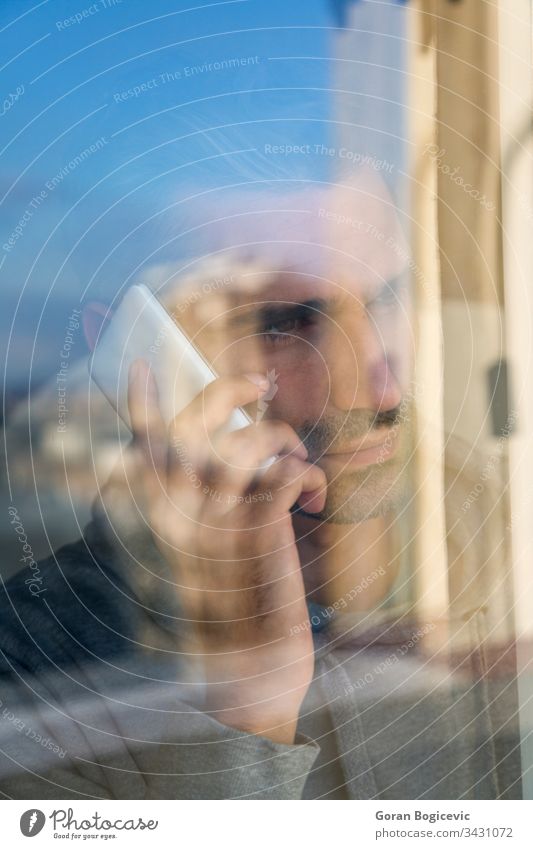 Junger Mann am Telefon Glas Mobile Menschen Funktelefon modern Business Fenster Kaukasier männlich Drahtlos benutzend Geschäftsmann Erwachsener Porträt