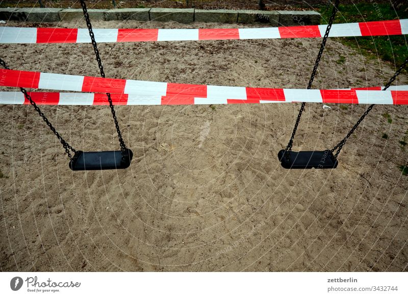 Gesperrte Schaukel auf dem Spielplatz absperrband absperrung ausgangssperre außen corona covid covid 19 flatterband hygiene isolation menschenleer seuche