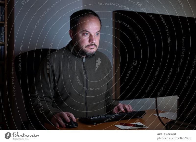 Mann der nachts im Homeoffice vor dem Computer sitzt pc Bildschirm Schreibtisch Technik & Technologie Internet Sitzen Arbeit Büro online Monitor Desktop Sucht