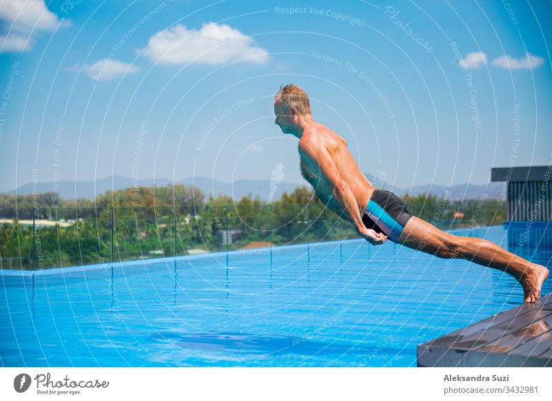 Unemotionaler Komiker, der in ein Schwimmbad fällt. Sommerurlaub Aktion aktiv Aktivität Erwachsener blau langweilig verrückt Krise Verzweiflung Emotion