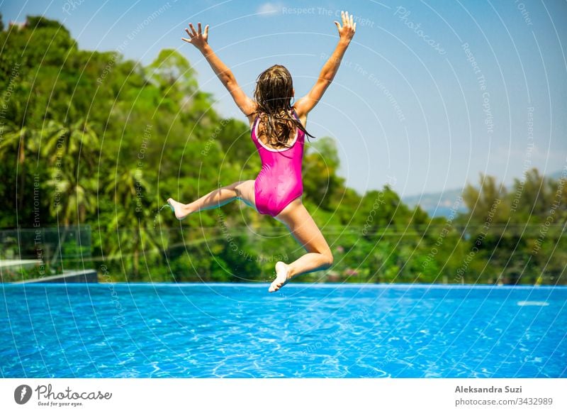 Aufgeregtes, lustiges, kleines Mädchen, das zum Swimmingpool springt. Fröhliche Sommerferien aktiv Abenteuer Asien blau offen sorgenfrei heiter Kind Kindheit