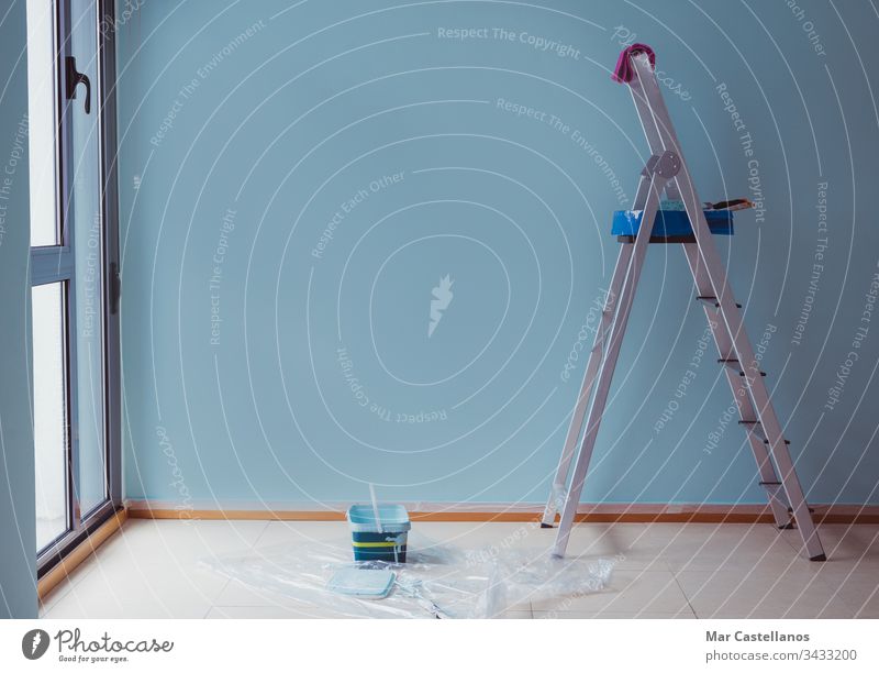Malertreppe mit frisch gestrichenem blauen Wandgrund. Arbeiten im Haus. Raum zum Kopieren. Anstreicher Treppenhaus Malerei Tablett Blauer Hintergrund
