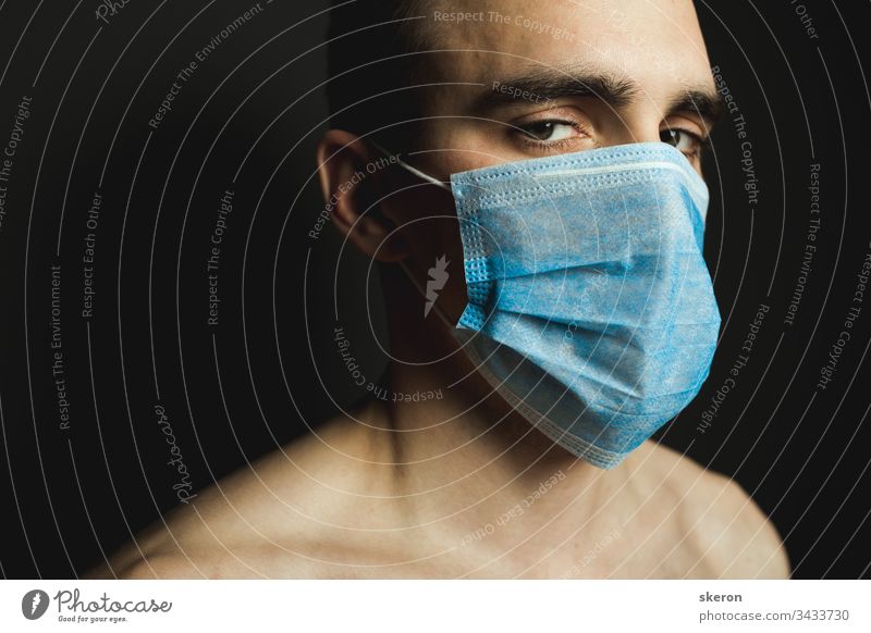 Porträt eines Mannes mit medizinischer Gesichtsmaske, der sich um die Prävention des pandemischen Coronavirus auf grauem Hintergrund kümmert. Quarantäne- und Pandemiekonzept. Mann mit aseptischer Maske zur Krankheitsprävention.
