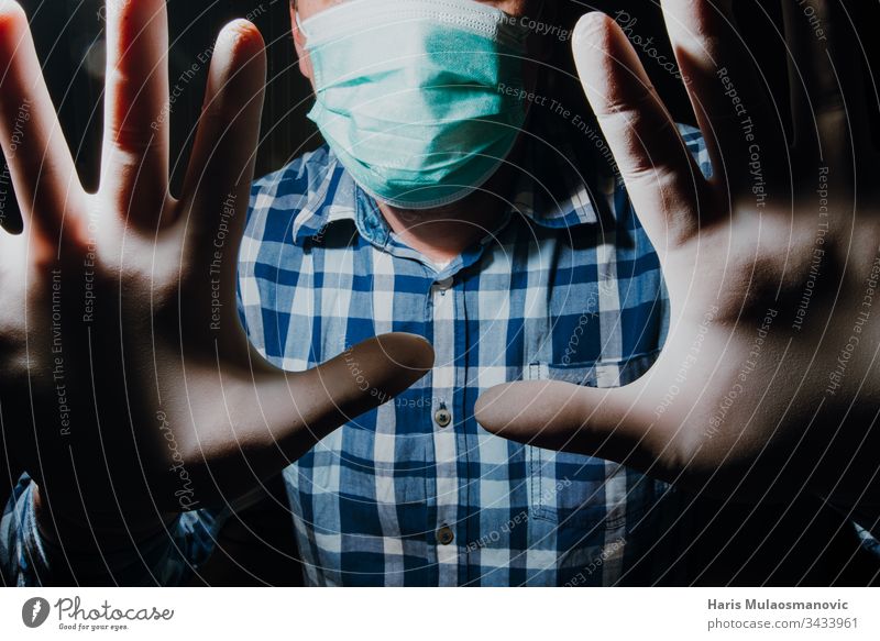Mann soziale Distanzierung mit Maske und medizinischen Handschuhen zum Schutz vor dem Coronavirus covid-19 Erwachsener apokalyptisch Hintergrund schwarz