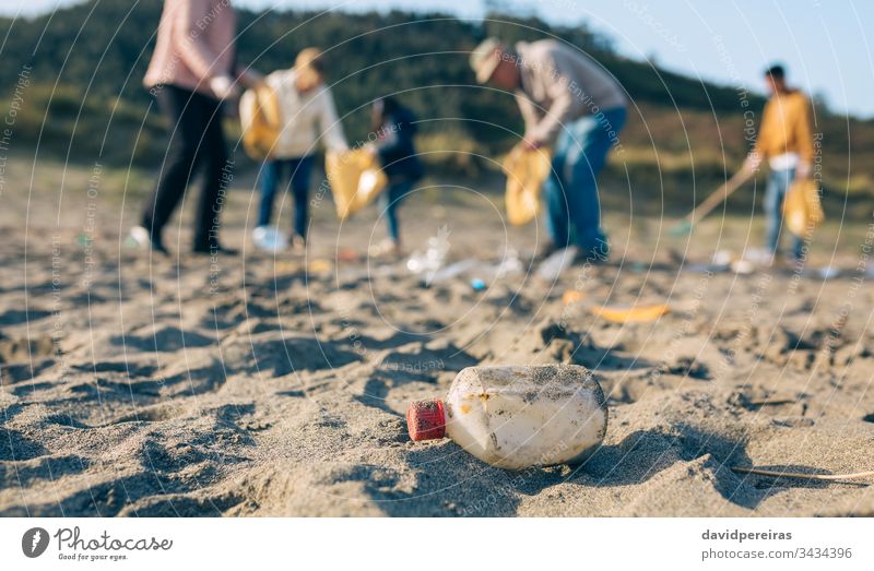 Freiwillige beim Putzen des Strandes Kunststoffflasche Reinigen Familie Freiwilligenarbeit dreckig Müllsäcke Umweltbewusstsein Menschengruppe Werkzeuge Kind