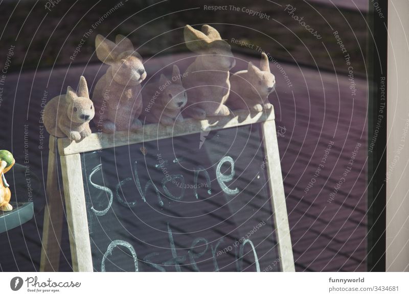 5 Osterhasen - figuren sitzen auf einer Tafel, auf der Frohe Ostern steht. Hase Dekoration Fenster Frühling abgesagt geschlossen einsam traurig handgeschrieben