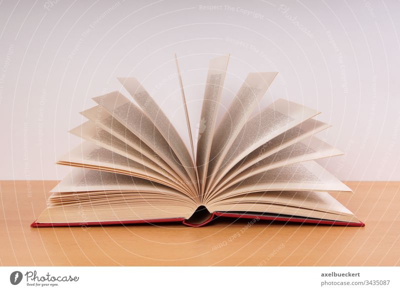 ein offenes Buch Hardcover Seiten Literatur Bildung Wissen Weisheit lesen Lernen altmodisch Schreibtisch Tisch Objekt Information Schule Universität Bibliothek