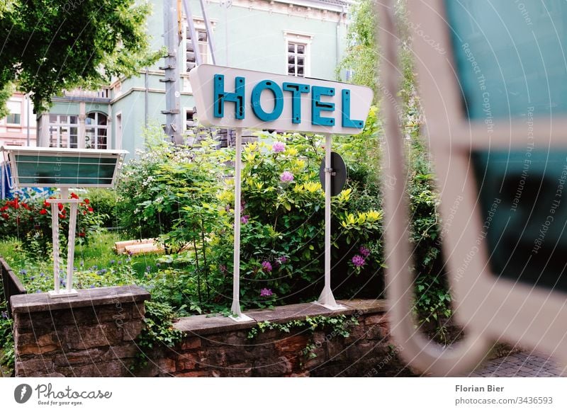 Typografisches Hotelschild an einem blühenden Garten in einer Einfahrt Typographie Buchstaben Schilder & Markierungen Zeichen Werbung Wort Hinweisschild