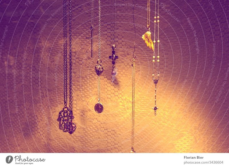 Beleuchtet und ausgestellter Schmuck mit religiösen Symbolen in Form von Ketten und Anhängern Schmuckanhänger Halskette Religion & Glaube Symbole & Metaphern