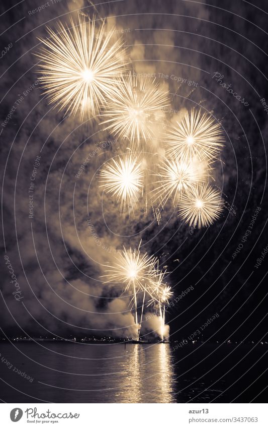 Luxus-Feuerwerk-Veranstaltung Himmel-Wasser-See-Show mit gelben Sternen. Hochwertiges Unterhaltungs-Zauber-Sternfeuerwerk z.B. zu Silvester oder zur Feier des Unabhängigkeitstages. Schöne Spiegelungen auf der Seeoberfläche