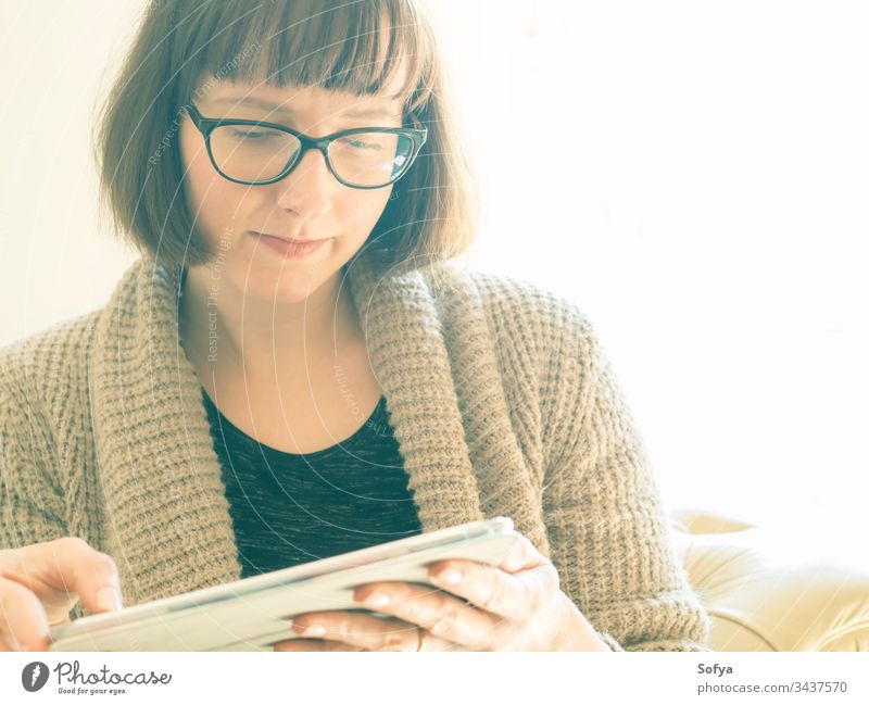 Kaukasische Frau mit Brille, die eine Tablette benutzt benutzend Arbeit von zu Hause aus Apparatur Gerät Sitzen Kaukasier Porträt konzentriert Quarantäne bob