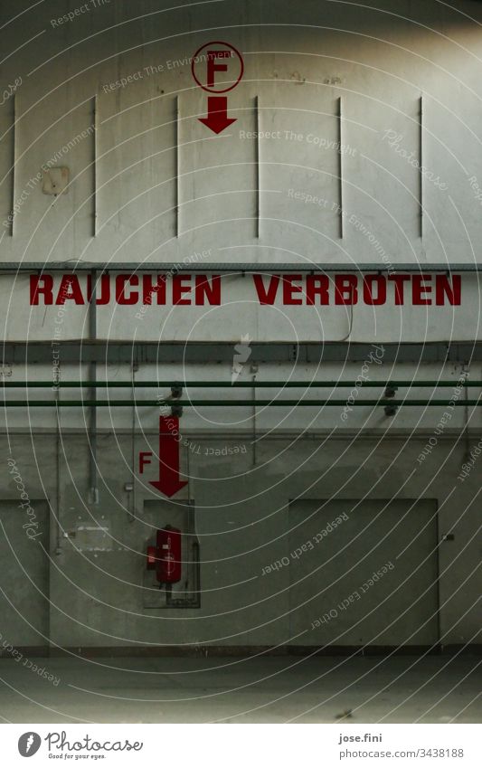 Rauchen verboten, steht in großen roten Buchstaben an der Wand der verlassenen Halle des Flugplatzes Raum alt Warnung gefährlich Feuer Feuerlöscher
