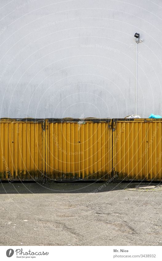 Müllcontainerbox Müllbehälter gelb Container Recycling dreckig Umweltverschmutzung Wand Lampe Metall Müllabfuhr Mauer Hinterhof Schatten Hauswand