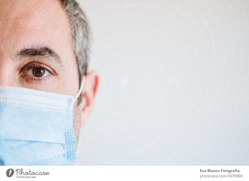 Nahaufnahme eines Arztes, der im Haus eine Schutzmaske und Handschuhe trägt. Coronavirus Covid-19-Konzept Porträt Mann professionell Corona-Virus Krankenhaus