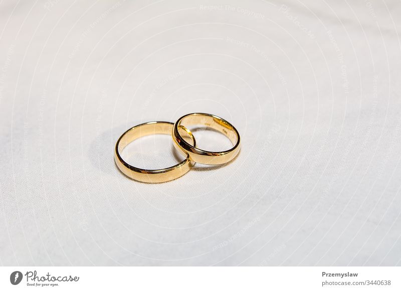 Zwei goldene Eheringe auf dem weißen Stoff Hochzeit Ring Liebe Symbol metallisch horizontal jevel heiraten Feier glänzend traditionell Paar Engagement Jahrestag