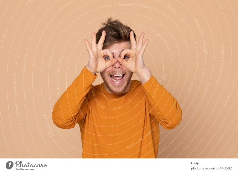 Attraktiver junger Mann Typ gelb orange herausschauen Beobachten Sie sehen beobachten Auge Watchman klatschend Brille Sehvermögen scoffing sich lustig machen
