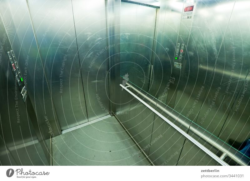 Im Fahrstuhl fahrstuhl lift kabine fahrstuhlkabine liftkabine haus wohnhaos hochhaus stockwerk etage metall glanz geländer stange haltestange balance tür