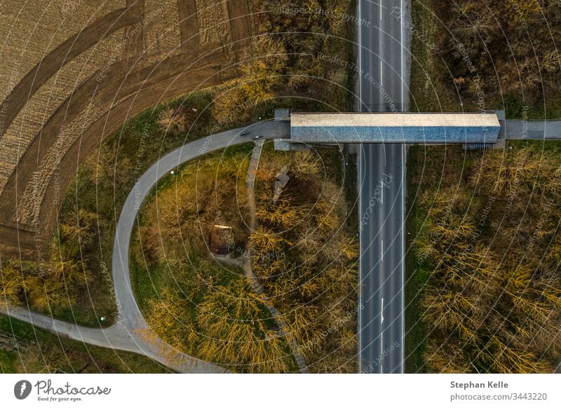Eine Straße mit Fußgängerbrücke aus vertikaler Draufsicht von einer Drohne aufgenommen Luftaufnahme Menschenleer Außenaufnahme Tag Verkehrswege Vogelperspektive