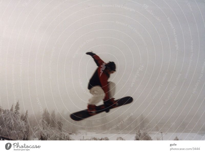 Boardgrab springen Snowboard Nebel Sport Schnee Berge u. Gebirge Snowboarder Snowboarding hoch 1 Außenaufnahme Farbfoto Textfreiraum oben Körperhaltung