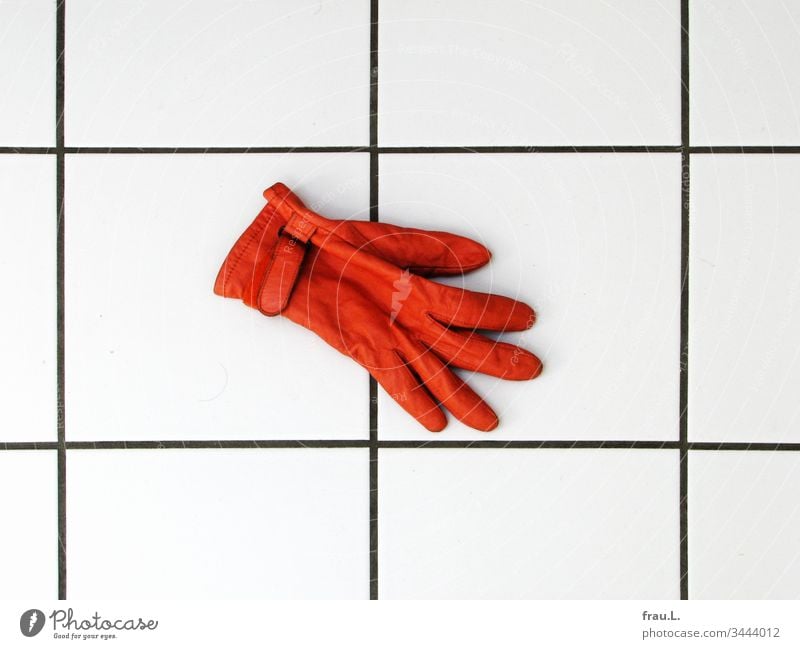 Der orange Handschuh fror auf den kalten Fliesen und er sehnte sich nach seinem Partner. Badezimmer Kacheln fußboden Leder Innenaufnahme Tag Fliesen u. Kacheln