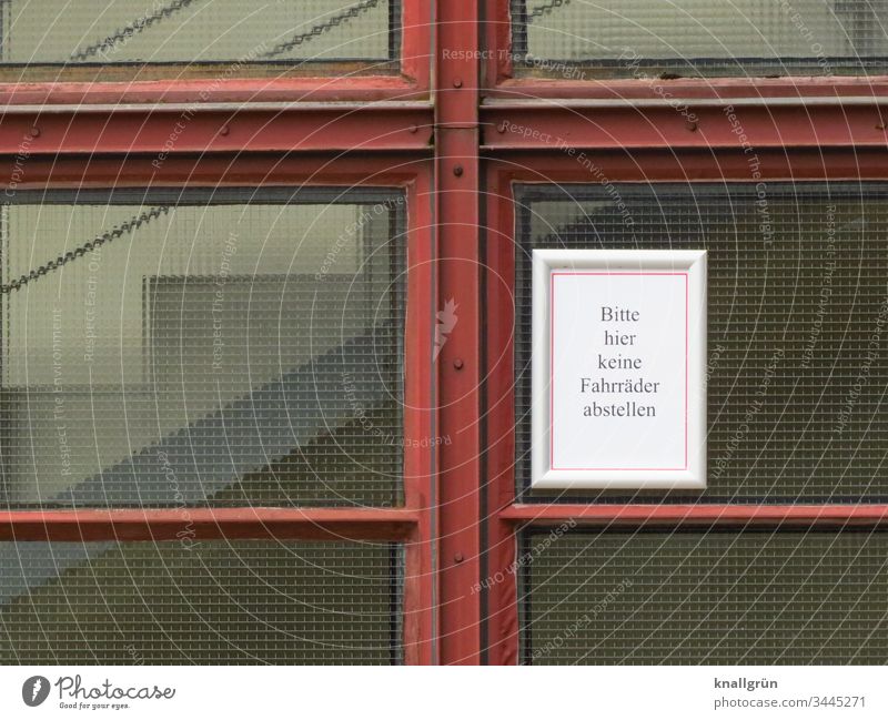 Hinweisschild „Bitte hier keine Fahrräder abstellen“ angebracht an einer Drahtglasscheibe eines Treppenhauses Verbotsschild Kommunizieren Verständigung