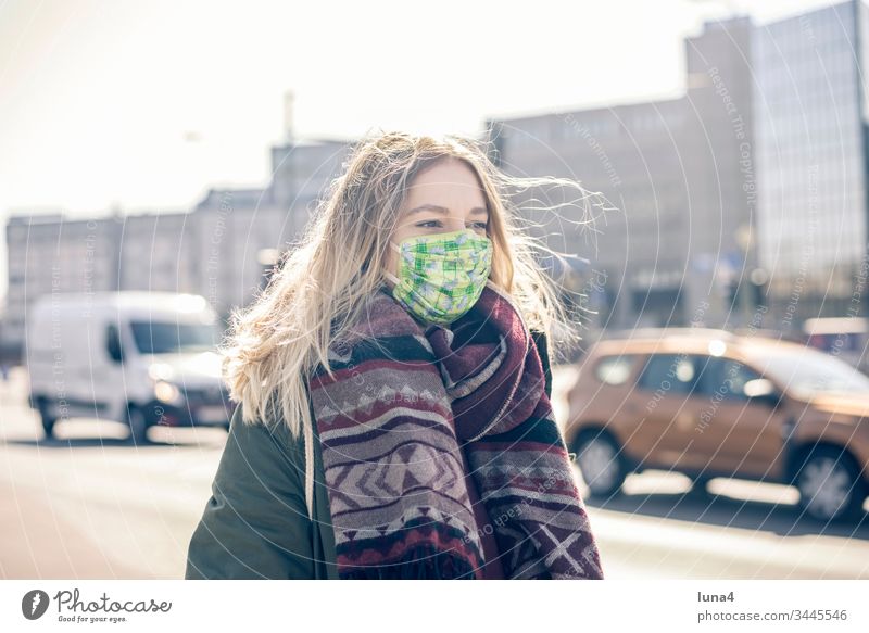 junge Frau mit Mundschutz in der Stadt Maske Atemschutzmaske Schutzmaske Virus Coronavirus besorgt Viren Pandemie Ansteckung bedrohlich Grippe anstecken