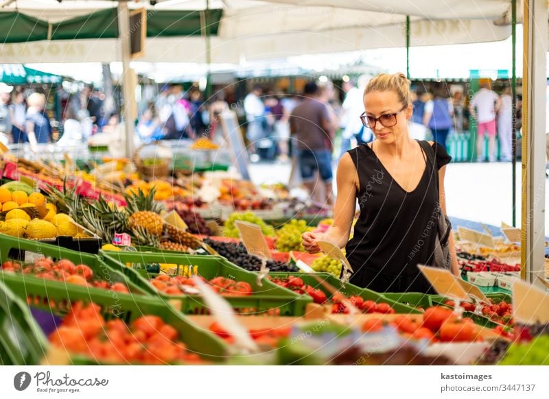 Frau kauft Obst und Gemüse auf dem örtlichen Lebensmittelmarkt. Marktstand mit verschiedenen Bio-Gemüsesorten kaufen organisch Vegetarier Früchte