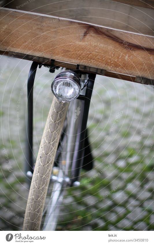 Lampe über dem Vorderrad eines Fahrrades mit Kiste aus Holz zum Transportieren, Einkaufen, auf Kopfsteinpflaster. Rad fahren Fahrradfahren Wege & Pfade Bewegung