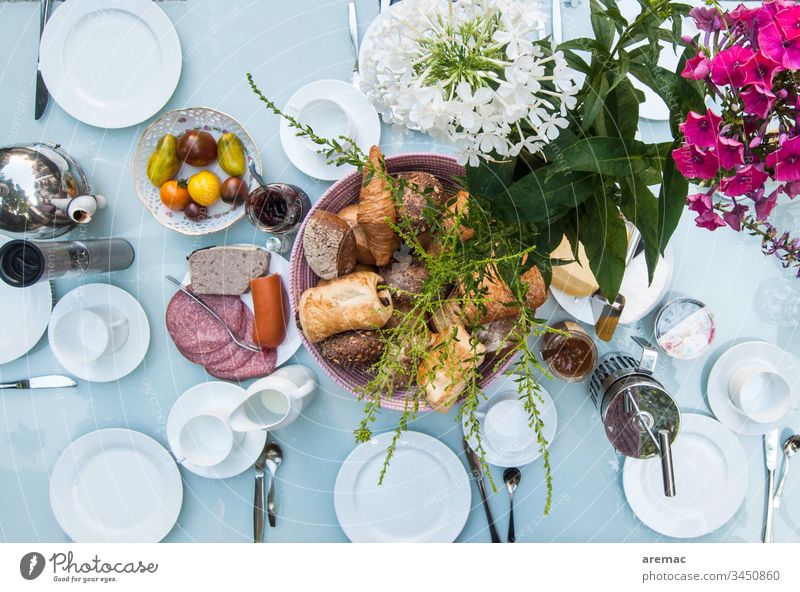 Frühstückstisch decken Tisch Geschirr weiß Blumen Wurstwaren rollen Tomaten bedeckt Farbfoto Lebensmittel Teller Innenaufnahme Backwaren Appetit & Hunger