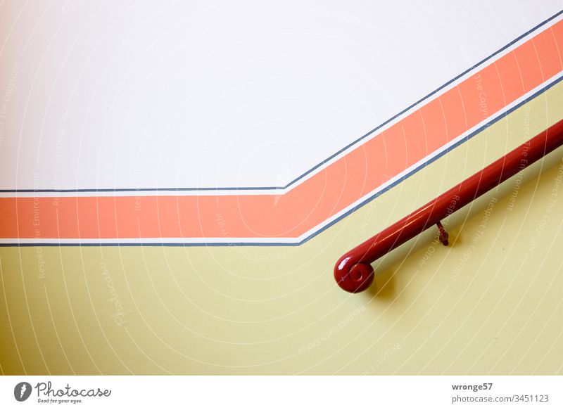 Hölzerner Handlauf konkurriert mit einem roten Farbstreifen in einem schick renovierten Treppenhaus Treppengeländer hölzern Altbau bunt weiß gelb Hauswand