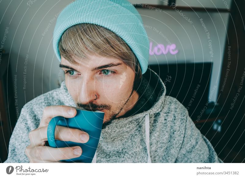 Junger Mann genießt eine Tasse Kaffee zu Hause männlich gemütlich heimwärts vereinzelt Quarantäne blau attraktiv gutaussehend Typ lässig anhaben Pyjama Tee