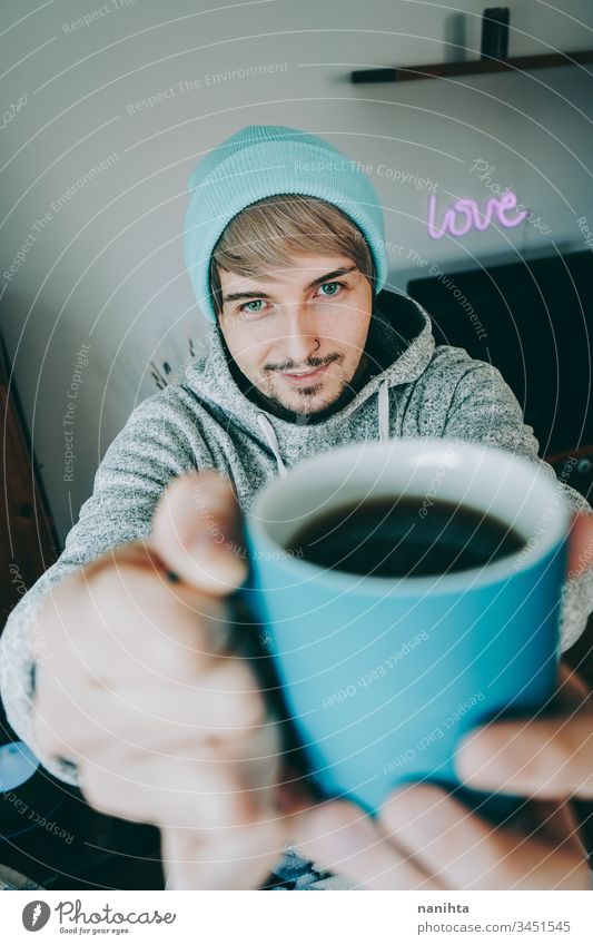 Junger Mann genießt eine Tasse Kaffee zu Hause männlich gemütlich heimwärts vereinzelt Quarantäne blau attraktiv gutaussehend Typ lässig anhaben Pyjama Tee