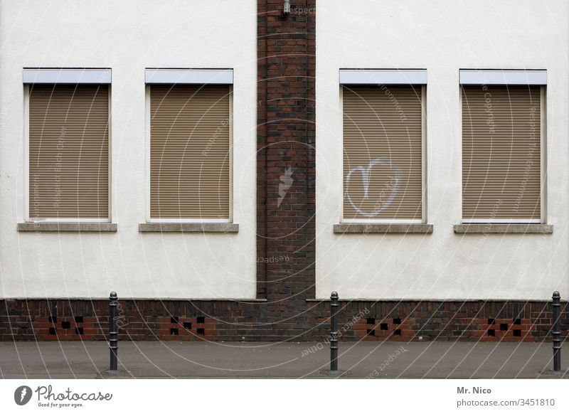 Fenster mit Herz Haus Gebäude Fassade Poller Architektur Bauwerk Straße Bürgersteig Rolladen geschlossen Klinkerfassade Putzfassade Symbole & Metaphern Graffiti