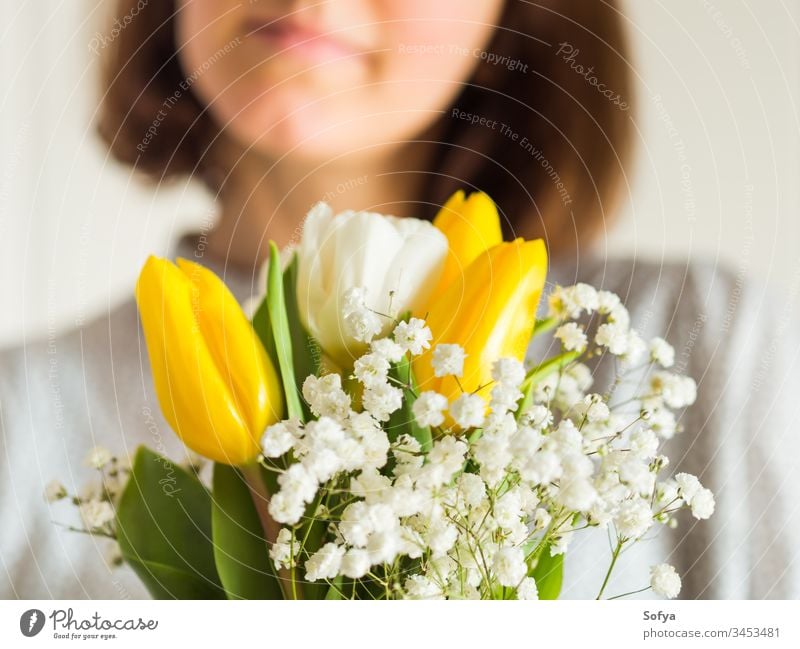 Frau hält Tulpenstrauß. Der Tag der Frau Blume Haufen Mutter geben Frühling Ostern Hände geblümt weiß gelb Dame März Geschenk Einladung Gruß Postkarte