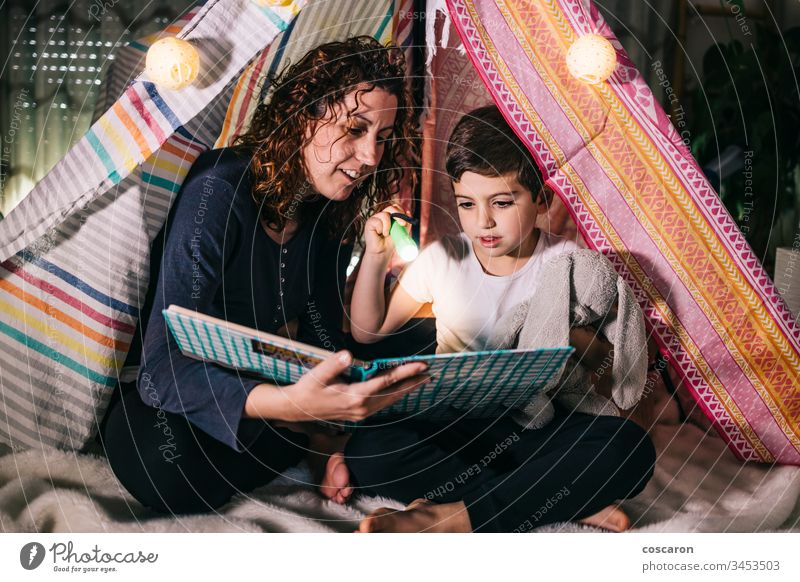Mutter und Sohn lesen zu Hause auf einem Zelt ein Buch schön Schlafzimmer Schlafenszeit Kaukasier Kind Kindheit Konzept niedlich dunkel Tochter Tag Bildung
