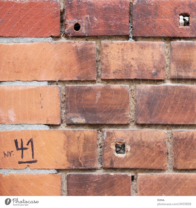 Notlösung ::: handschriftlich notierte Hausnummer auf alter schlecht verfugter Backsteinmauer mit 3 Löchern haus fassade urban Tageslicht Wand kaputt oberfläche