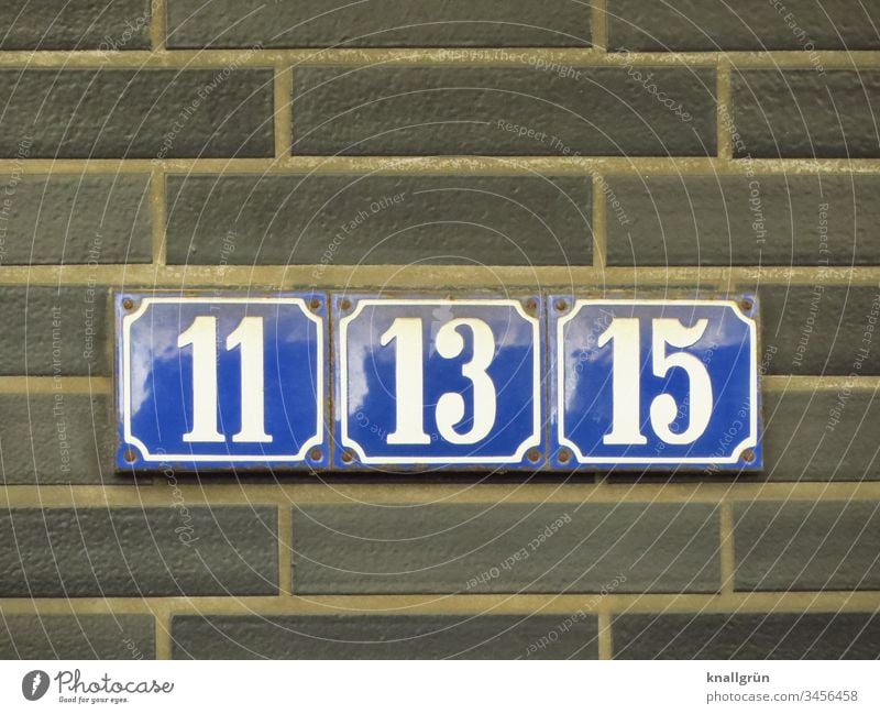 Drei dicht nebeneinander angeschraubte blau emaillierte Hausnummern mit weißen Zahlen 11, 13 und 15 Hausnummernschild Ziffern & Zahlen Emailleschild