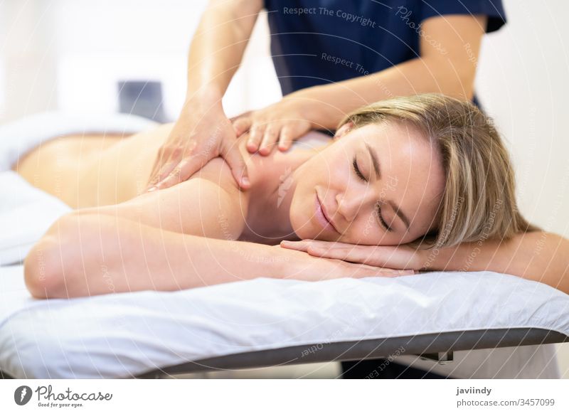 Frau, die auf einer Bahre liegt und eine Rückenmassage erhält. Massage Spa Körper schön Behandlung Lächeln Salon Schönheit Pflege Therapie jung Erholung Mädchen