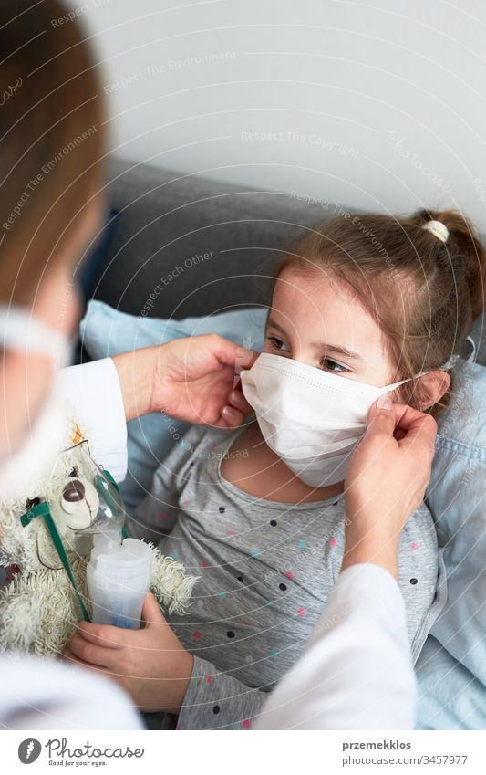Der Arzt bedeckt das Gesicht des kleinen Patienten mit einer Maske. Erkranktes Mädchen bei medizinischer Inhalationsbehandlung mit Vernebler Kind Virus