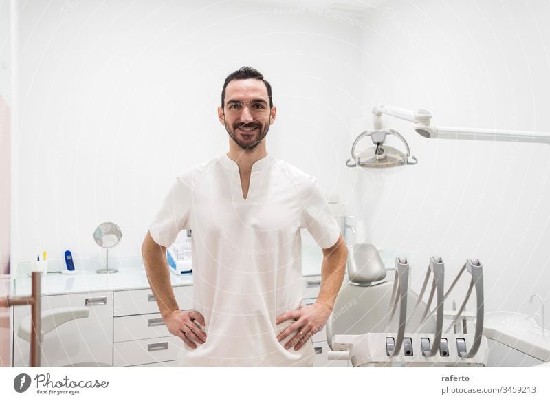 Porträt eines lächelnden männlichen Arztes, der in einer Zahnarztpraxis posiert Klinik Glück Gesundheitswesen dental Pflege bärtig professionell Zahnmedizin