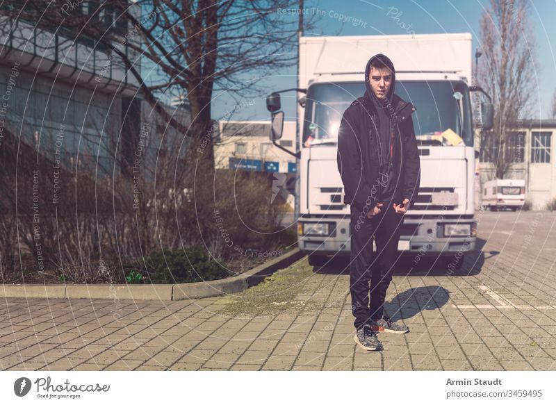 junger Mann mit Rucksack steht vor einem Lastwagen Teenager Lifestyle Lastkraftwagen Porträt aeria Architektur schön schwarz Junge Gebäude lässig Kaukasier
