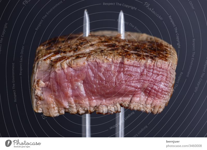 gegrilltes Steak auf einer Fleischgabel close-up besteck sirloin steak braten Hintergrund weiß geschnitten rot essen geröstet saftig Qualität Abendessen Essen