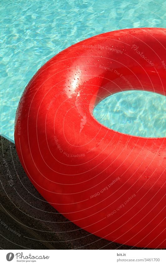 Prall gefüllt, liegt der große, rote Schwimmring am Rand vom Schwimmbecken, im türkisen Wasser. Schwimmen & Baden Schwimmbad Sommer blau Freude